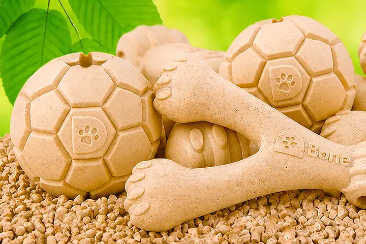 D-Bone balls and wishbones resting on a bed of Naturion granulate, green foliage behind them.